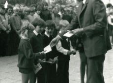 5165.Inauguracja roku szkolnego w Szkole Podstawowej w Kunowie (2 wrzesnia 1974 r.)-dyrektor Henryk Mackowiak przyjmuje pierwszoklasistow wreczajac dzienniczki uczniowskie jako symbol ucznia