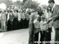 5166.Inauguracja roku szkolnego w Szkole Podstawowej w Kunowie (2 wrzesnia 1974 r.)-dyrektor Henryk Mackowiak przyjmuje pierwszoklasistow wreczajac dzienniczki uczniowskie jako symbol ucznia