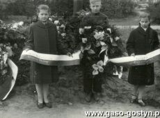 5727.Pogrzeb na gostynskim cmentarzu 30 mieszkancow rozstrzelanych w 1939 roku przez hitlerowcow i 9 powstancow wlkp. (Gostyn, 11 kwietnia 1957 r.)-  nad mogila mlodziez ze Szkoly Podstawowej nr 1