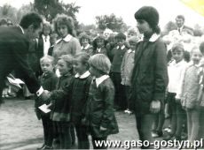 631.Rozpoczecie roku szkolnego w Szkole Podstawowej w Kunowie (1973r.)-dyr szkoly wrecza pierwszoklasistom dzeinniczki ucznia