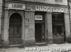8296.Sklep PSS Spolem w domu przy ulicy 1 Maja 2 w Gostyniu 1. polowa lat 80. XX wieku), dom wybudowano w 1902 roku